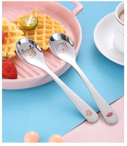Detail view of 304 stainless steel baby spoons with engraved giraffe and bear patterns