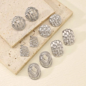 Set of six silver hammered square and textured stud earrings on beige stone base