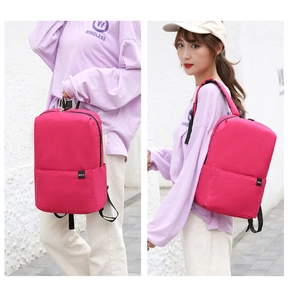 Detail showing the adjustable black shoulder straps and hand-carry handle of the pink backpack