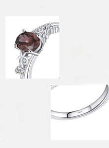 Macro detail of S925 silver ring featuring red zircon and intricate vine engravings