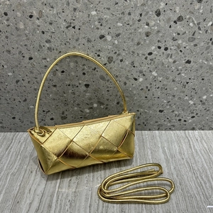 Detailed view of golden woven leather handbag with a matching long crossbody strap