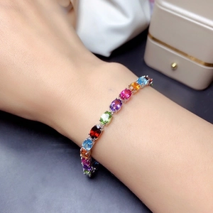 Dettaglio del bracciale con pietre preziose multicolori e catena in argento lucido
