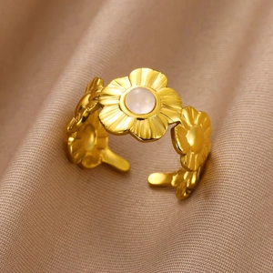 Vintage 18K gold plated flower ring with round natural stone on beige fabric background