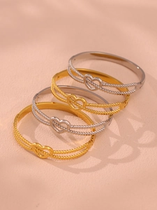 Vue détaillée de quatre bracelets cœur en or et argent avec texture perlée empilés