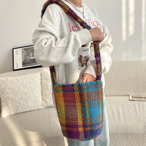 Detail of colorful plaid bucket bag in fuzzy faux shearling worn over the shoulder