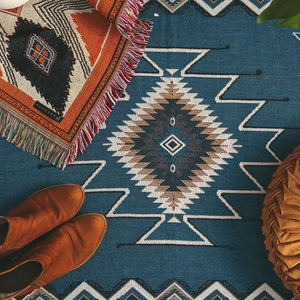 Detailed view of bohemian woven picnic blanket with ethnic geometric patterns and fringe
