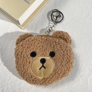 Dettaglio di un portamonete a forma di orso in peluche marrone con portachiavi in metallo