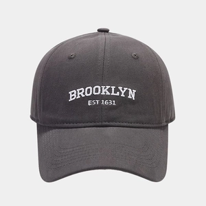 Detailed view of white Brooklyn Est 1631 embroidery on a charcoal grey cotton baseball cap