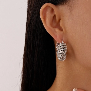 Vue macro de boucles d'oreilles créoles géométriques en U argentées avec cristaux