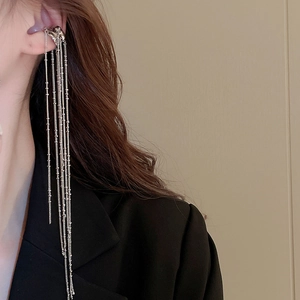 Detail of silver long chain tassel ear cuff on model with elegant fringe jewelry design