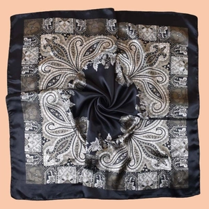 Detailed macro view of black paisley silk scarf with classic vintage pattern texture