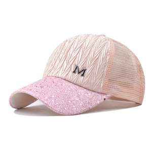 Detailed view of pink mesh baseball cap with sequined brim and silver M metal logo