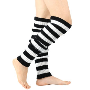Detailed knit texture of black and white striped leg warmers in a stylish slouchy fit