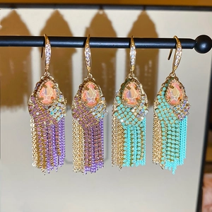 Macro detail of bohemian teardrop zircon earrings with layered long metal chain tassels