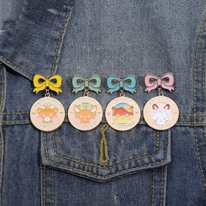 Set of four cartoon animal enamel pins featuring a bear, deer, otter, and rabbit on denim