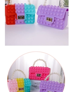 Detail of colorful pop-it fidget bag with pearl handle and golden metallic buckle