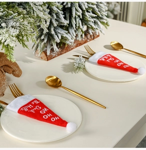 Detail of Christmas cutlery holders with HO HO embroidery on festive white plates