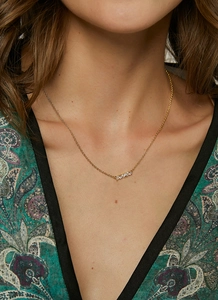 Detailed view of elegant gold necklace featuring shimmering cubic zirconia pendant on neck