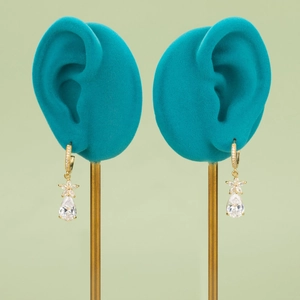 18k gold plated floral stud earrings with teardrop gemstones on teal display stands