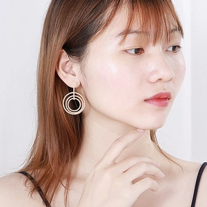 Three-layer circular titanium steel stud earrings in gold finish for a modern geometric look