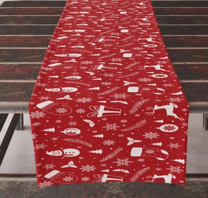 Detail of red Christmas table runner with white reindeer and snowman patterns on wood table