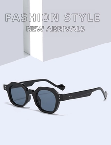 Detail of black polygon sunglasses with blue lenses and decorative silver rivets