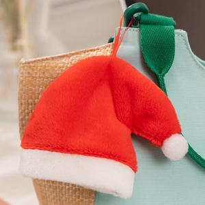 Close-up of a plush red and white Christmas hat pendant with soft furry texture