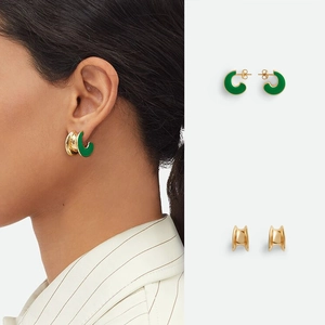 C-shaped 18K gold plated earrings with dark green enamel finish on a model and flat lay