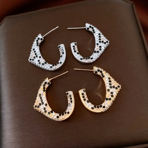 Macro shot of 18K gold plated C-shaped leopard print earrings with sparkling zircons