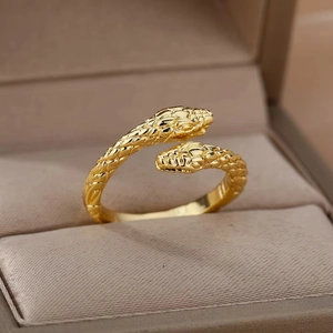 Macro detail of golden double-headed snake ring with textured scales in a jewelry box