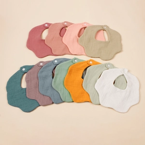 Collectie veelkleurige bloemblad-vormige katoenen gaas baby slabbetjes op beige basis