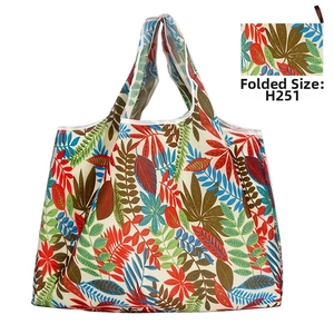 Detailed view of portable oxford cloth tote bag showing tropical leaves pattern and folded state