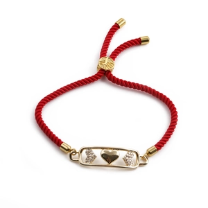 Adjustable red rope bracelet with gold-plated heart charms and cubic zirconia stones