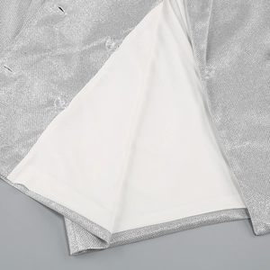 Close-up of silver sequin shirt fabric with white lining and transparent buttons