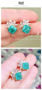 Macro view of gold stud earrings featuring square emerald zircon and pear-cut petal stones