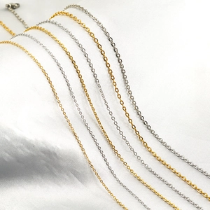 Classic 18K gold and silver stainless steel O-chains displayed on white silk texture