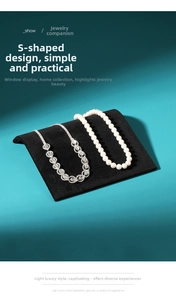 Detail of black velvet S-shaped jewelry display stand showing necklace arrangement