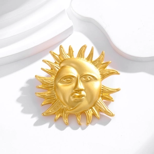Vintage gold sun and moon face brooch with matte finish on geometric white background