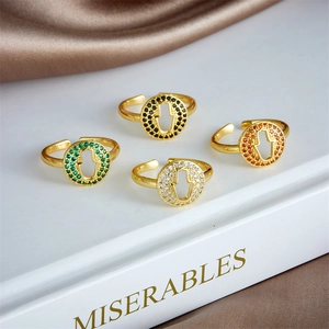 Set of four gold-plated Hamsa Hand rings with colorful zircons on a silk backdrop