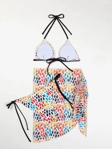 Detailed flat lay of a 3-piece floral bikini set including a sarong with colorful dots