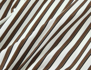 Gros plan macro du tissu à rayures verticales marron, blanc et noir à texture tissée