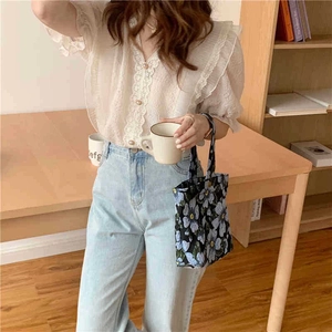 Blue floral jacquard shoulder bag paired with white lace shirt and denim jeans