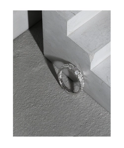 Detail of silver S925 ring featuring organic lava texture and shimmering zircon stones