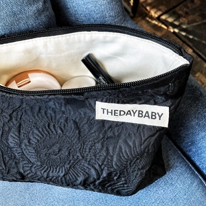 Detail view of large capacity makeup bag with floral jacquard and interior cosmetics
