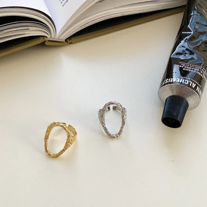 Detailed view of irregular textured adjustable rings in gold and silver finishes