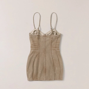 Détail d'une mini-robe en jean marron avec motif moucheté blanc et fines bretelles