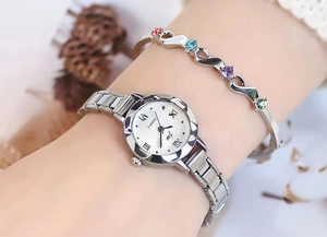 Detail view of a silver quartz watch and gem bracelet set on a female wrist