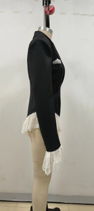 Detail of elegant white lace trim on the sleeve of a black slim fit bodysuit blazer