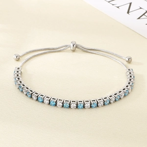 Detail of silver tennis bracelet with alternating blue and white cubic zirconia stones