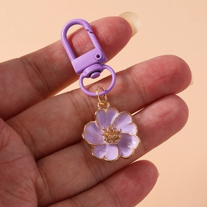 Close-up of a purple metal flower keychain with matching purple spring clasp accessory